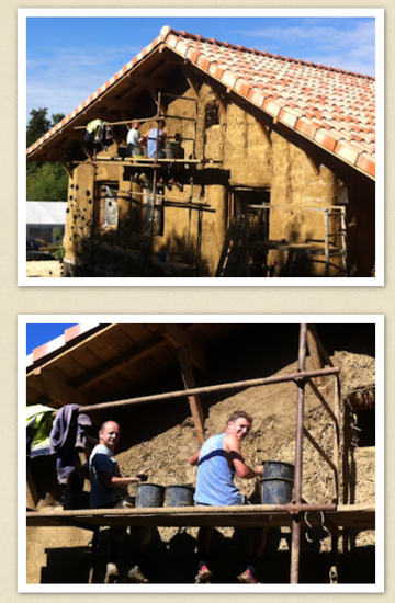 Straw bales stacked between wooden frame during mid-construction of load-bearing wall, showing proper building technique and 